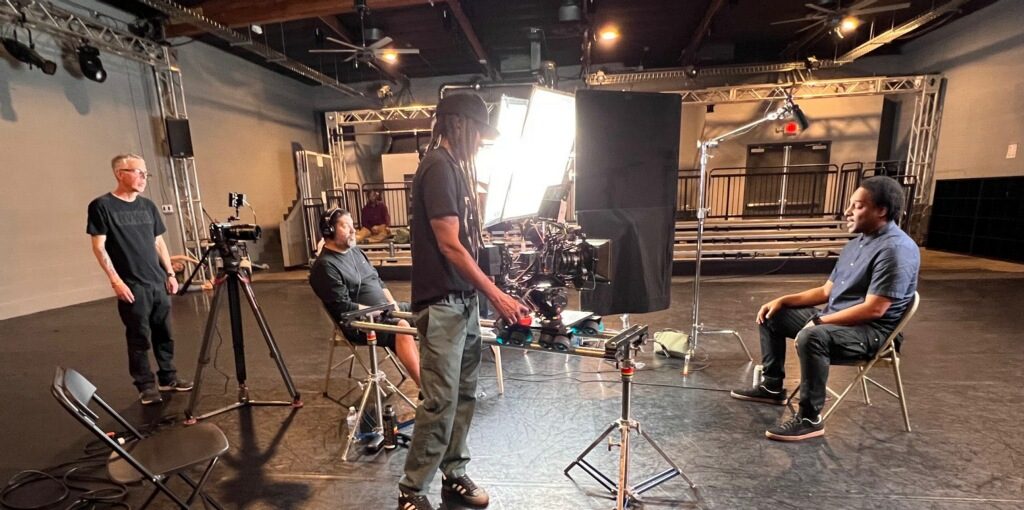 Full crew setting up a professional interview in a large venue